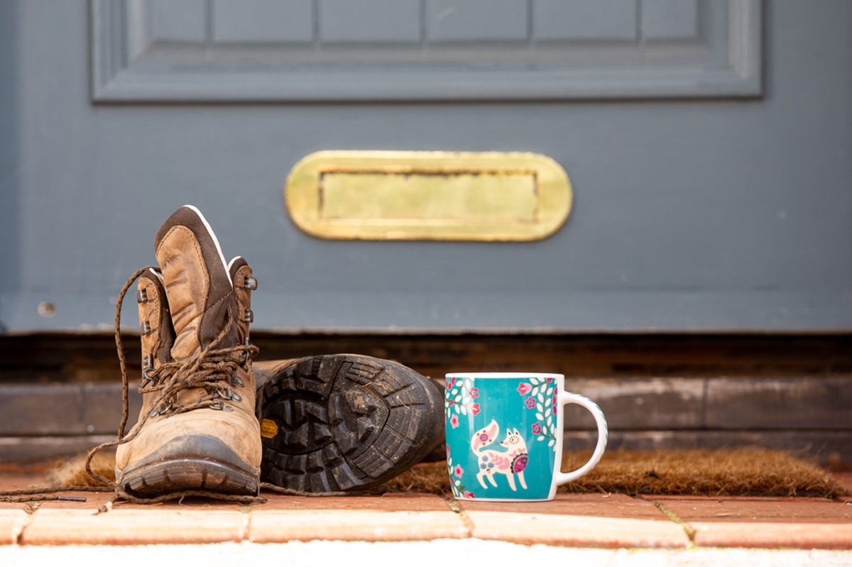 Boots and mug at front door of a country home